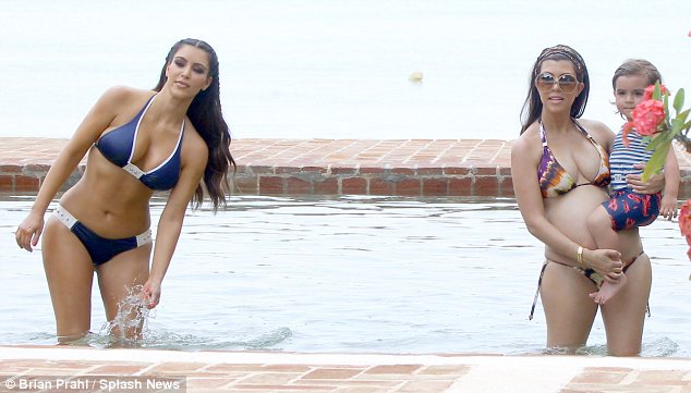 Kim was seen splashing water onto herself while Kourtney picked up Mason in the pool