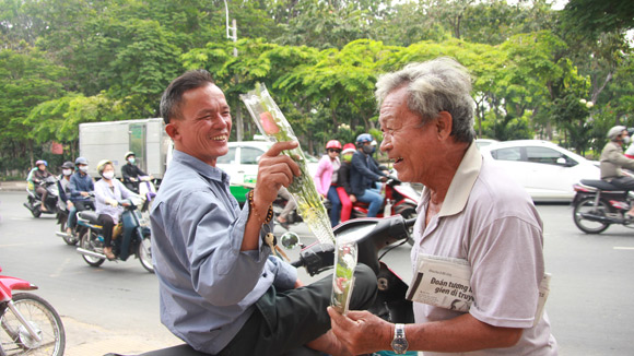 Tình nguyện viên Sài thành tặng hoa cho người bán hàng rong